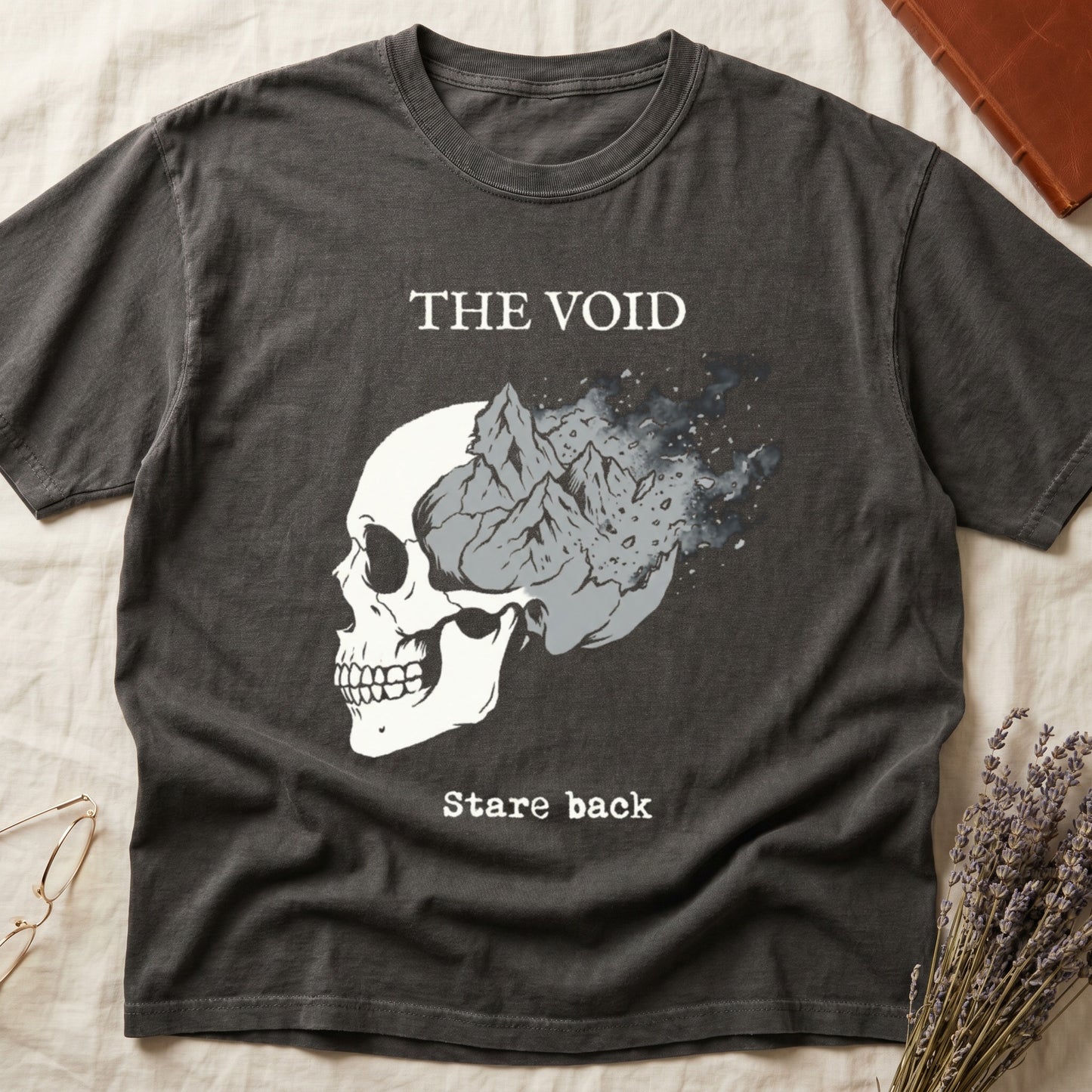 Pepper tee with skull eroding into mountain landscape and stardust, "THE VOID" top, "Stare back" typewriter below.