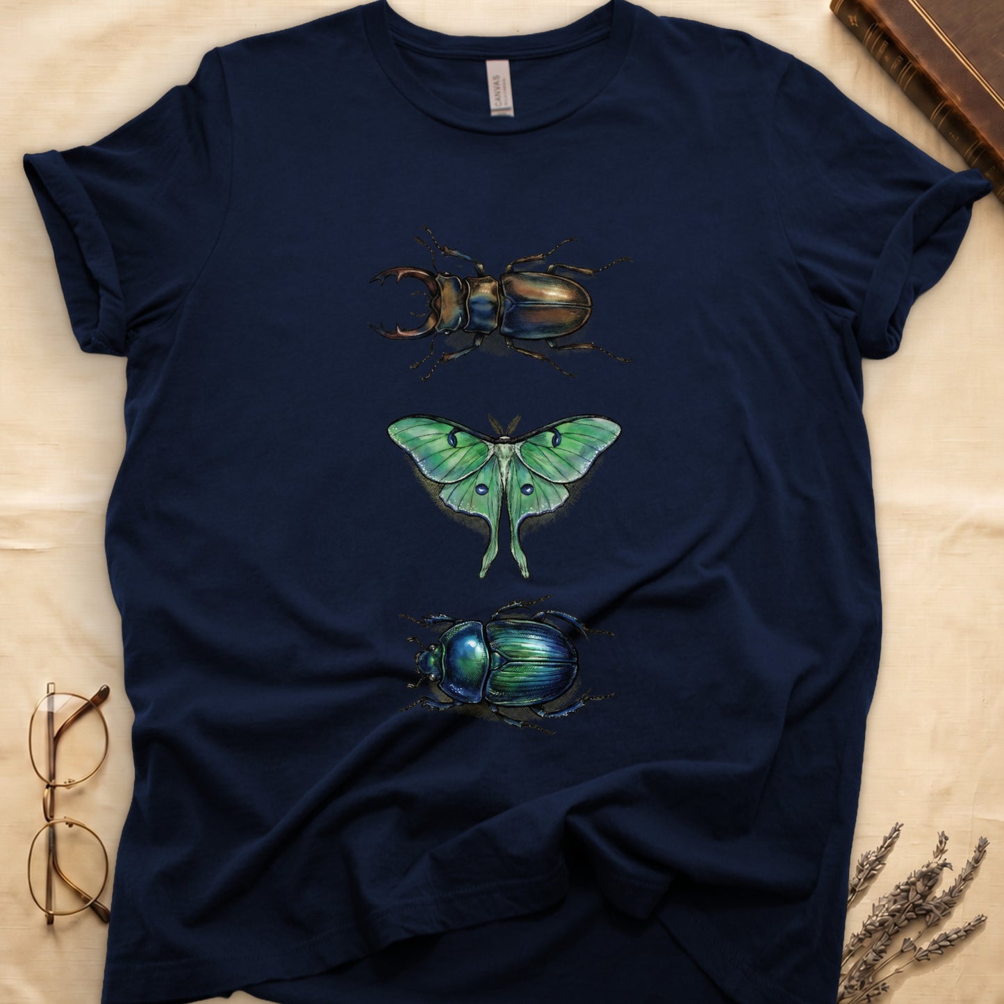 Black tee with three-panel Navy-history plate: stag beetle, luna moth, scarab beetle in ink on yellow ground.