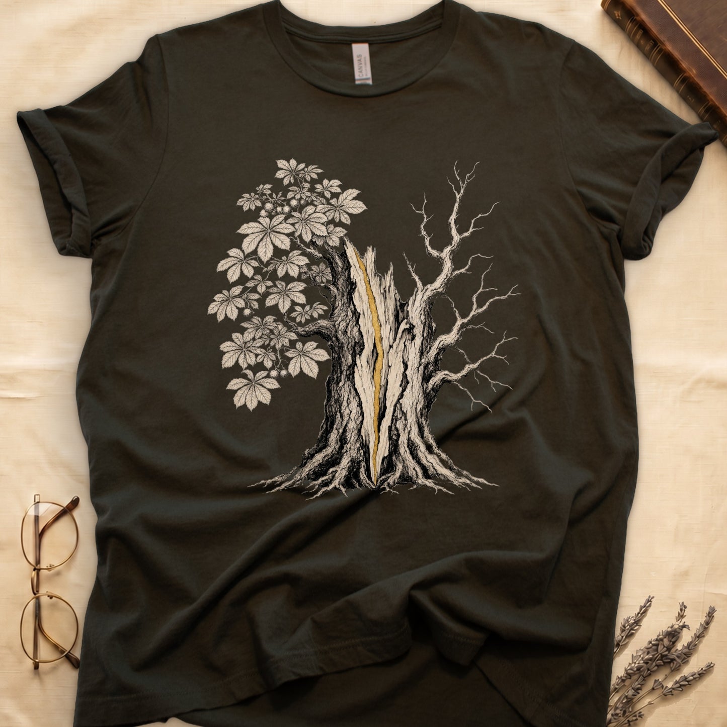 Dark t-shirt with an illustration of a cracked tree with leaves and bare branches.