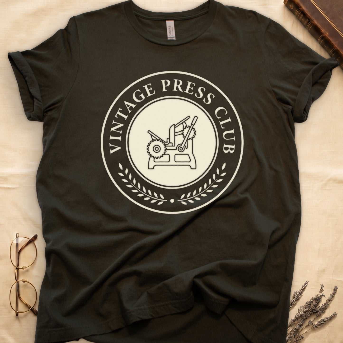 Military Green tee with circular letterpress badge, "VINTAGE PRESS CLUB" in serif capitals, antique printing press in cream linework.