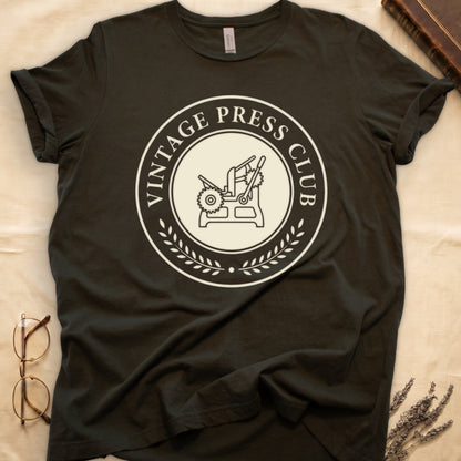 Military Green tee with circular letterpress badge, "VINTAGE PRESS CLUB" in serif capitals, antique printing press in cream linework.
