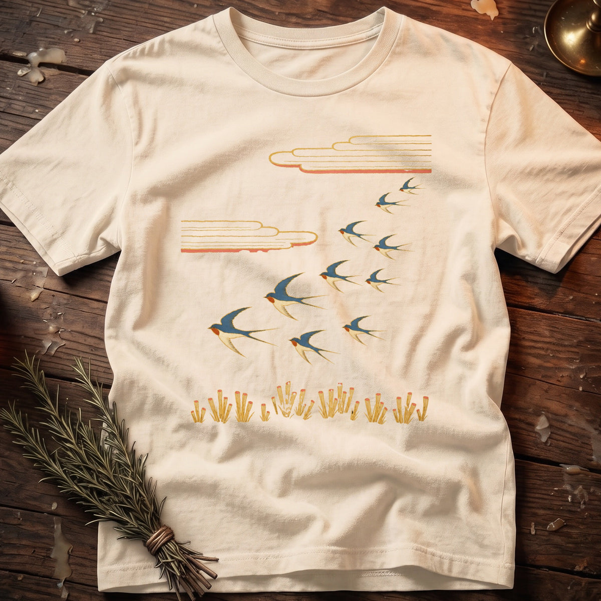 White t-shirt with flock of swallows flying above stylized reeds.