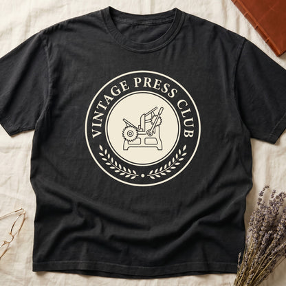 Black tee with circular letterpress badge, "VINTAGE PRESS CLUB" in serif capitals, antique printing press in cream linework.