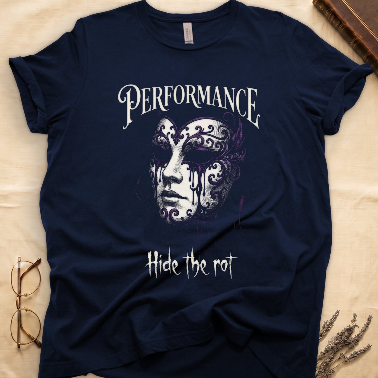 Navy tee with ornate Venetian mask in cream and purple filigree dripping ink, "PERFORMANCE" top, "Hide the rot" below.