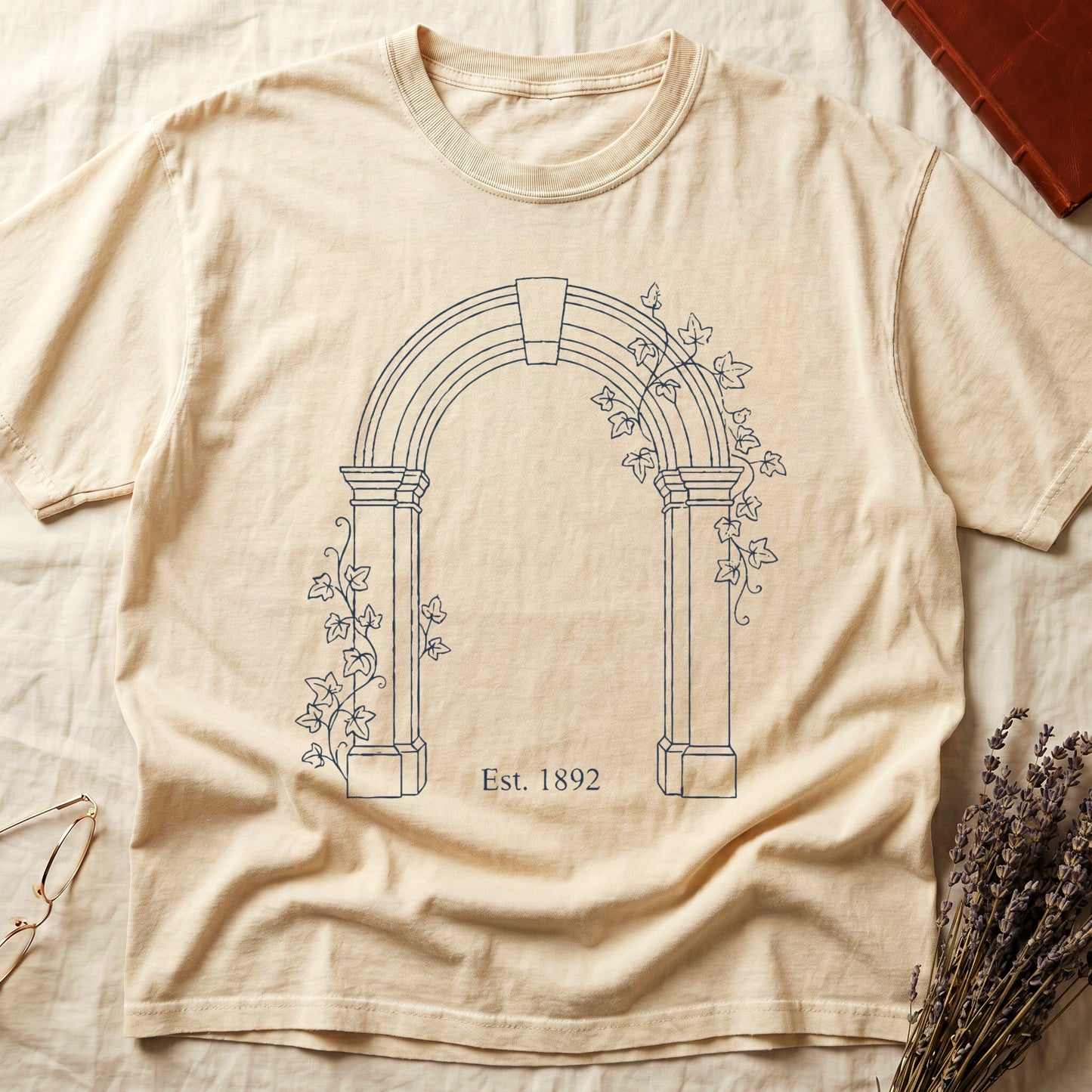 Ivory tee with Gothic stone archway in cream linework, ivy climbing the columns, "Est. 1892" inscribed at the base.