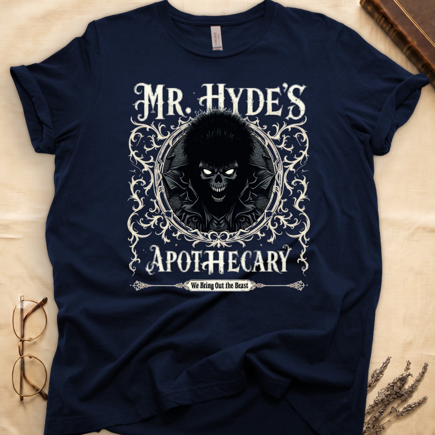 Black tee with ornate filigree frame, wild-haired skull figure, "MR. HYDE'S APOTECARY," "We Bring Out the Beast" below.