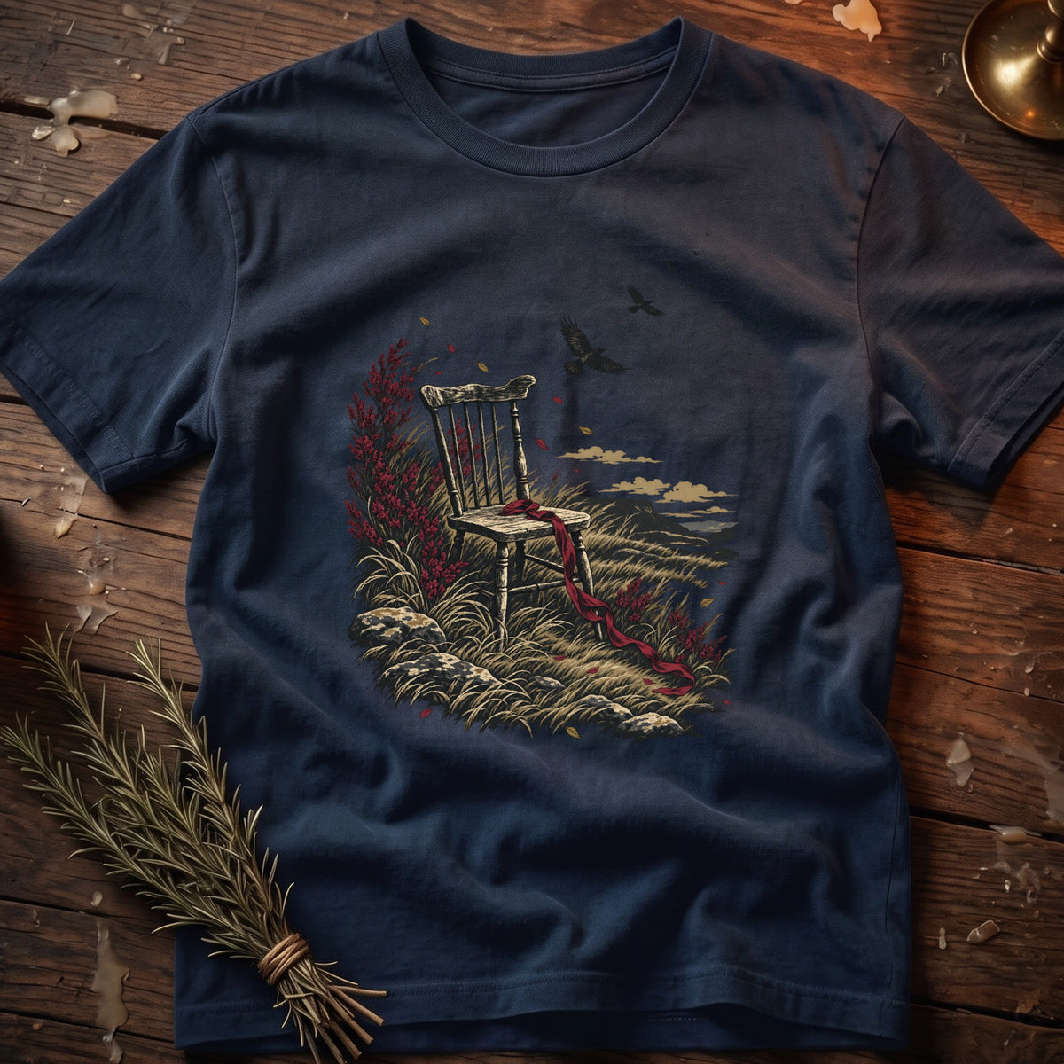 T-shirt with graphic of wooden chair, red ribbon, and birds in a field.