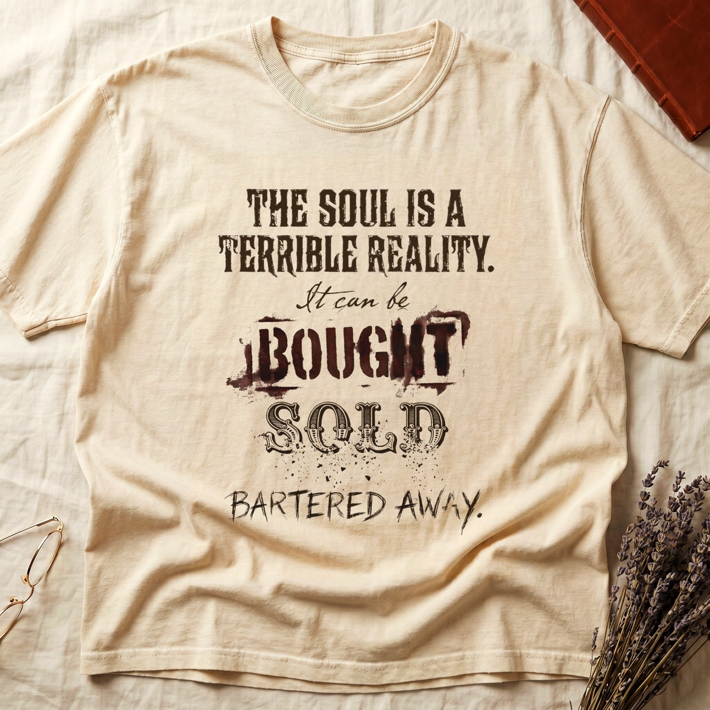 Ivory tee with distressed western type, "THE SOUL IS A TERRIBLE REALITY. It can be BOUGHT SOLD BARTERED AWAY."
