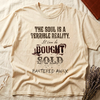 Ivory tee with distressed western type, "THE SOUL IS A TERRIBLE REALITY. It can be BOUGHT SOLD BARTERED AWAY."