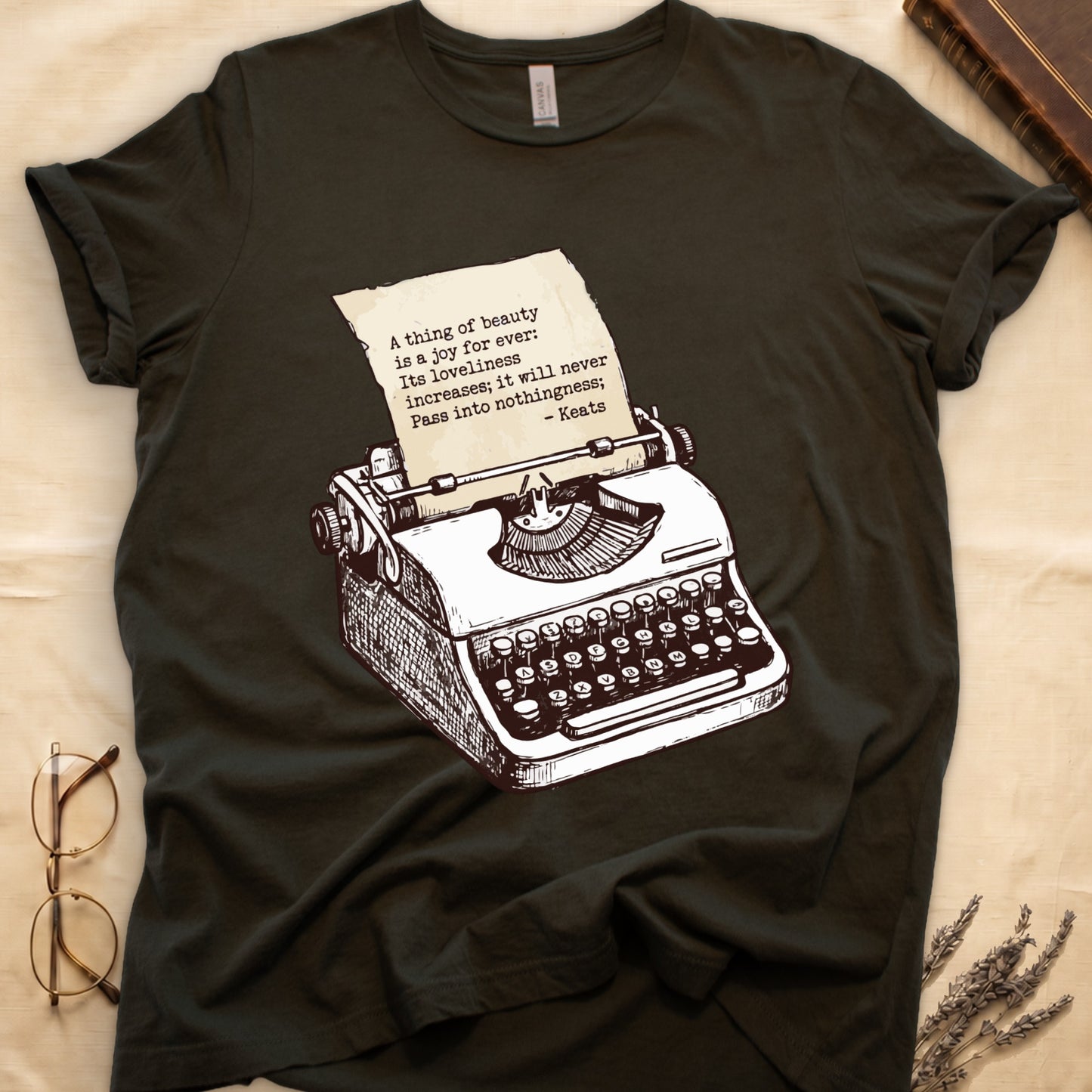 Military Green tee with vintage typewriter in cream linework, paper showing "A thing of beauty is a joy for ever" by Keats.