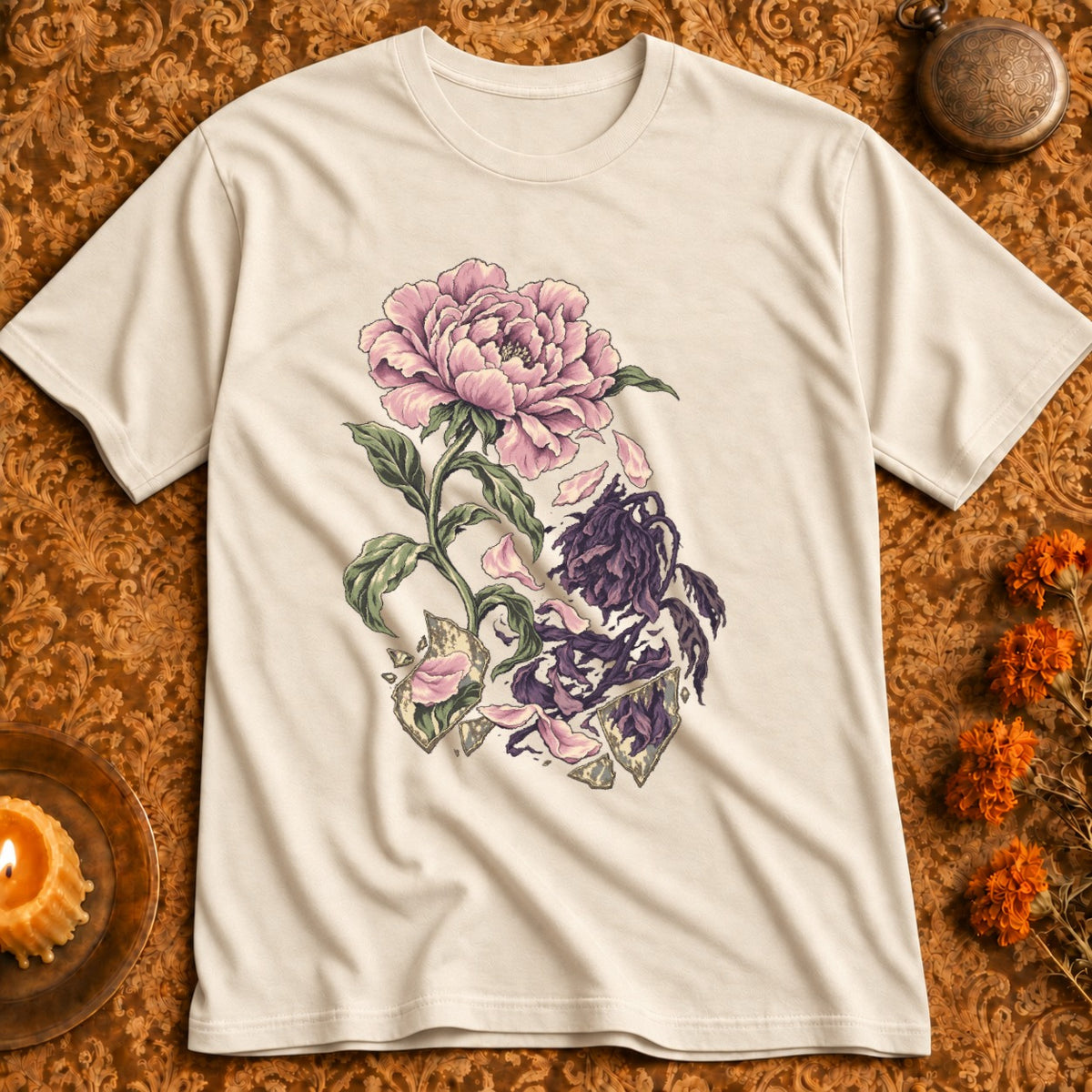 Cream t-shirt with a broken flower illustration of a blooming pink peony and wilted purple flowers.