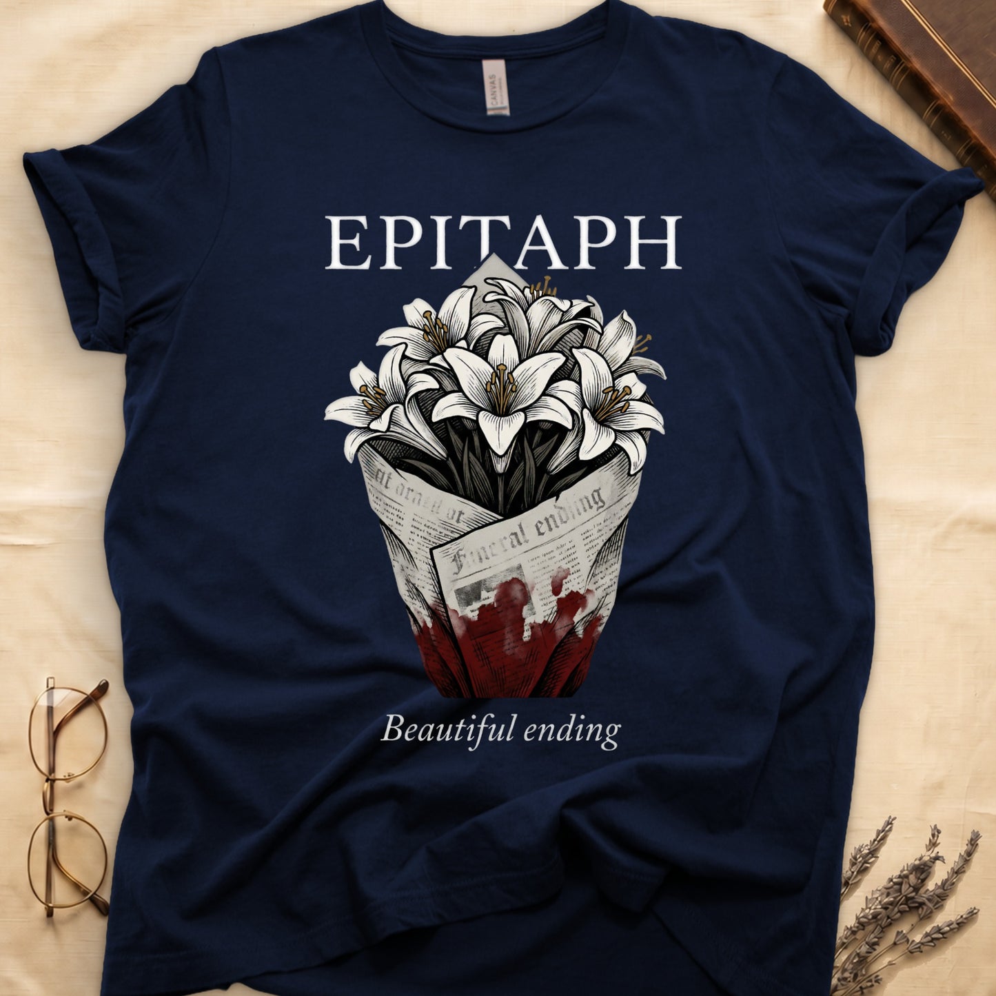 Navy tee with "EPITAPH" over crosshatched white lilies in blood-stained newsprint wrap, "Beautiful ending" italic serif.