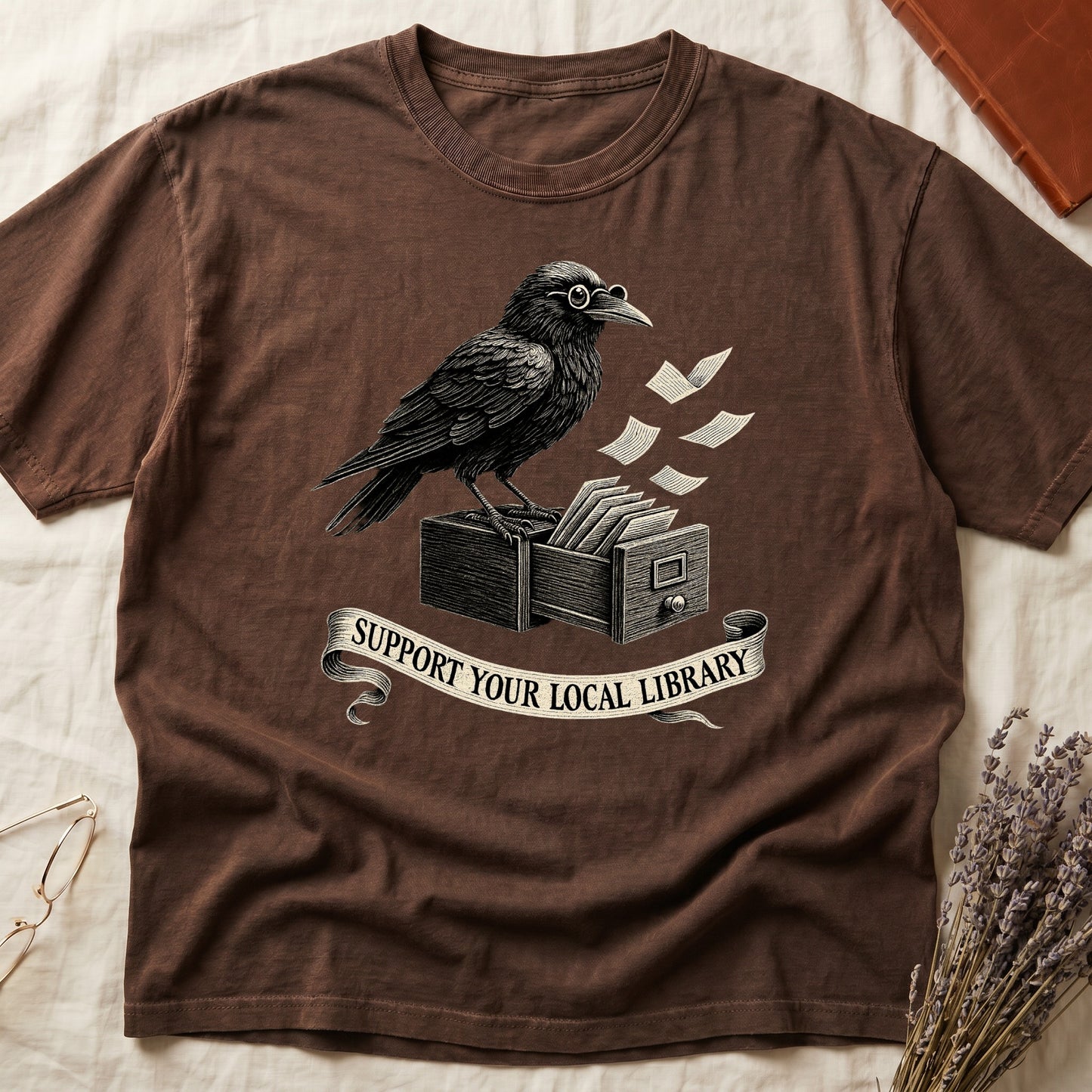 Black tee with raven writing on "823.4" parchment by candlelight, ink jar beside, "MIDNIGHT CATALOGUER" banner above.
