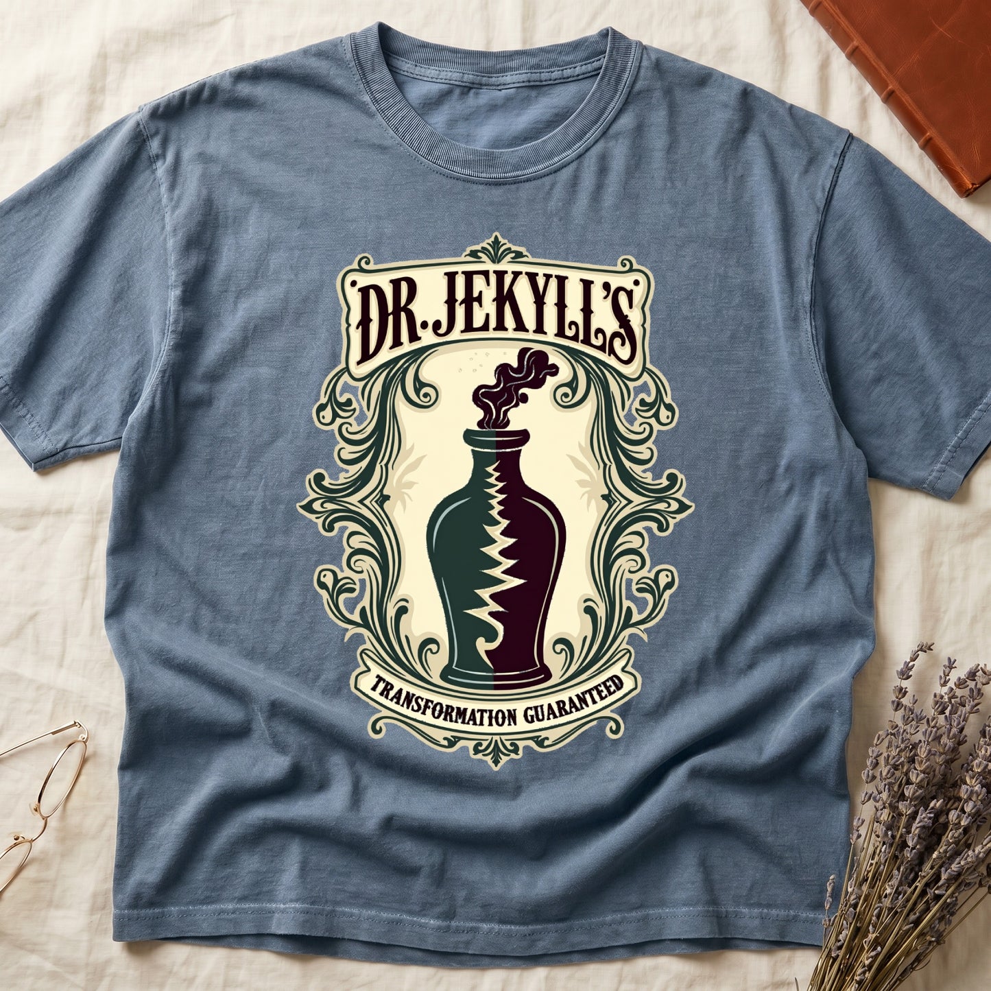 Blue Jean tee with apothecary label, green elixir bottle, lightning bolt, smoke, "DR. JEKYLL'S," "TRANSFORMATION GUARANTEED."