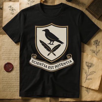Black tee with cream-and-gold heraldic shield, black raven over crossed quills, scroll banner "SCIENTIA EST POTENTIA" below.
