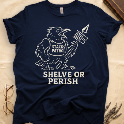 Navy tee with vintage raven mascot, "STACKS PATROL" sash, feather pen aloft, "SHELVE OR PERISH" bold serif below.
