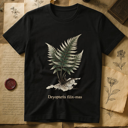 Black tee with Victorian fern illustration of Dryopteris filix-mas in greens with exposed root, italic Latin binomial below.