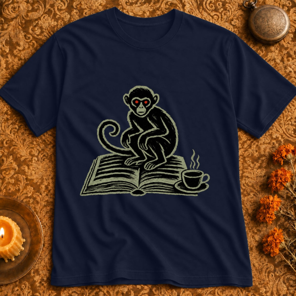 Dark navy t-shirt featuring a monkey with red eyes sitting on an open book next to a coffee cup.