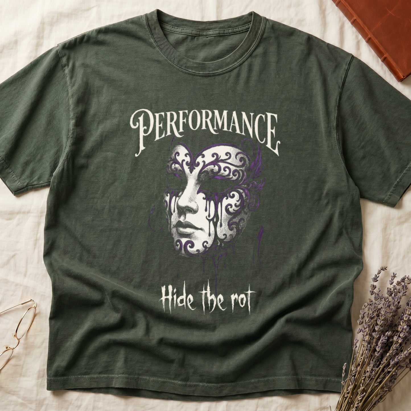 Green tee with ornate Venetian mask in cream and purple filigree dripping ink, "PERFORMANCE" top, "Hide the rot" below.