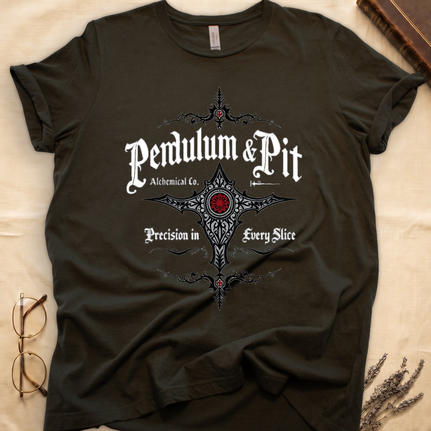 Military Green tee with white talismanic cross, "Pendulum & Pit Alchemical Co.," "Precision in Every Slice" banner ribbons.