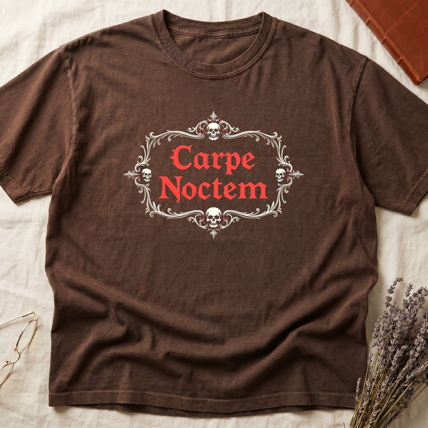 Espresso tee with silver filigree cartouche, crowned skull top and skull below, "Carpe Noctem" in deep-red blackletter inside.
