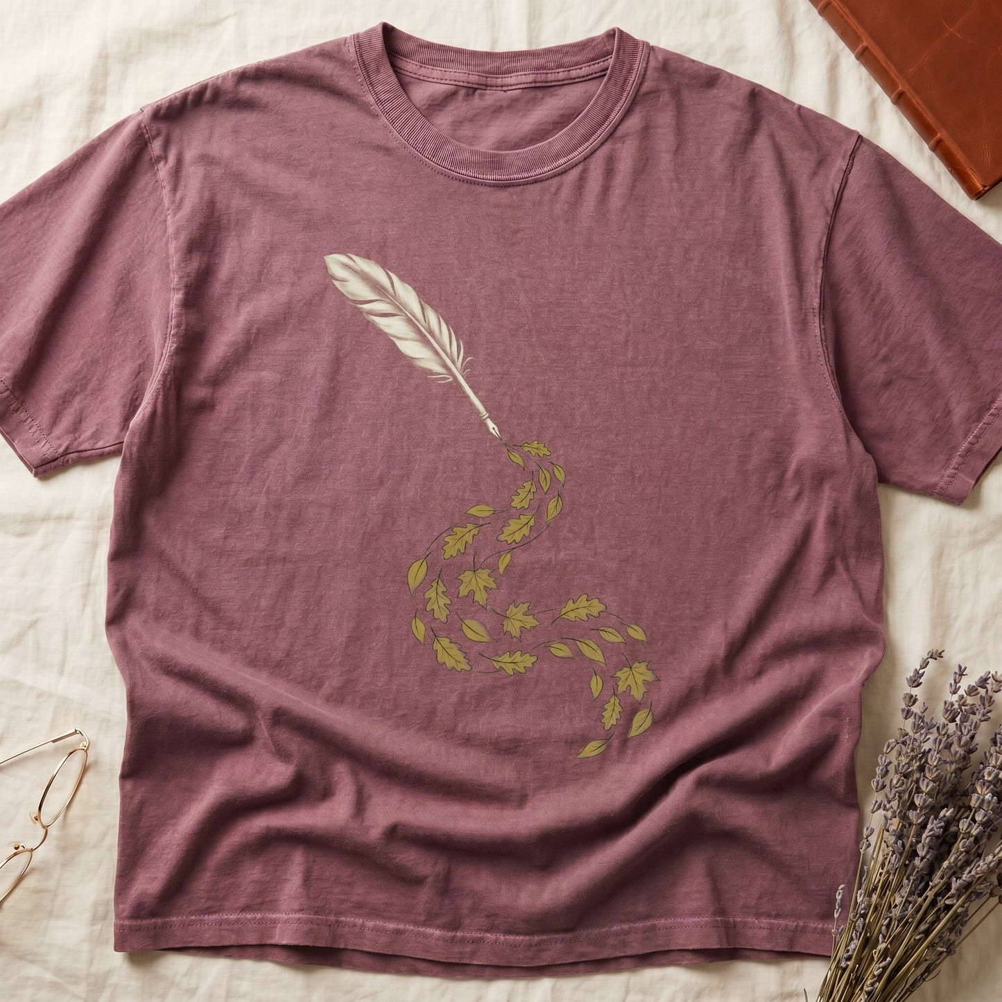 Dark Rose tee with antique quill pen in cream linework, oak and maple leaves cascading from the nib in gold and green.