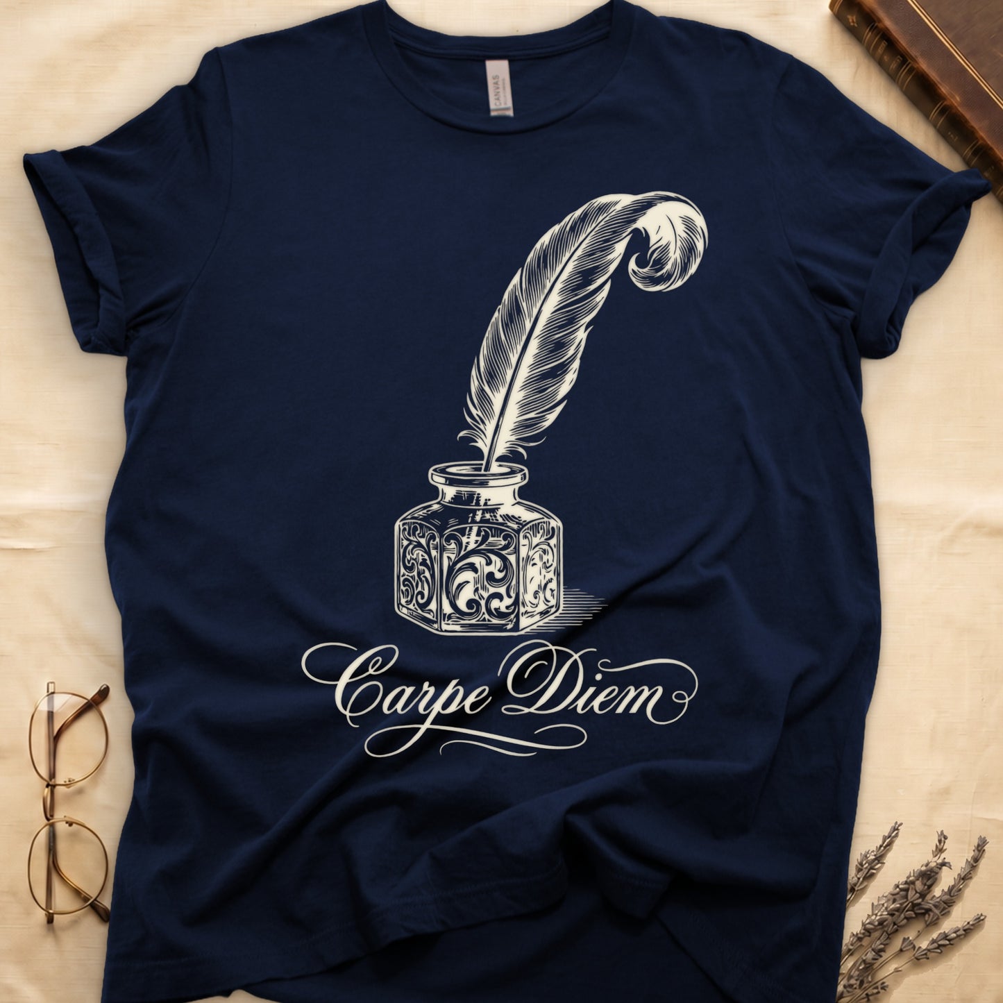 Navy tee with ornate antique inkwell and quill pen in sepia linework, "Carpe Diem" in flowing cursive below.