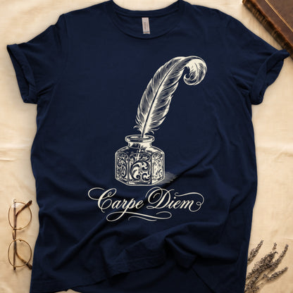 Navy tee with ornate antique inkwell and quill pen in sepia linework, "Carpe Diem" in flowing cursive below.
