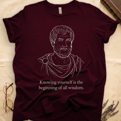 Maroon tee with classical philosopher bust in cream linework, "Knowing yourself is the beginning of all wisdom" below.