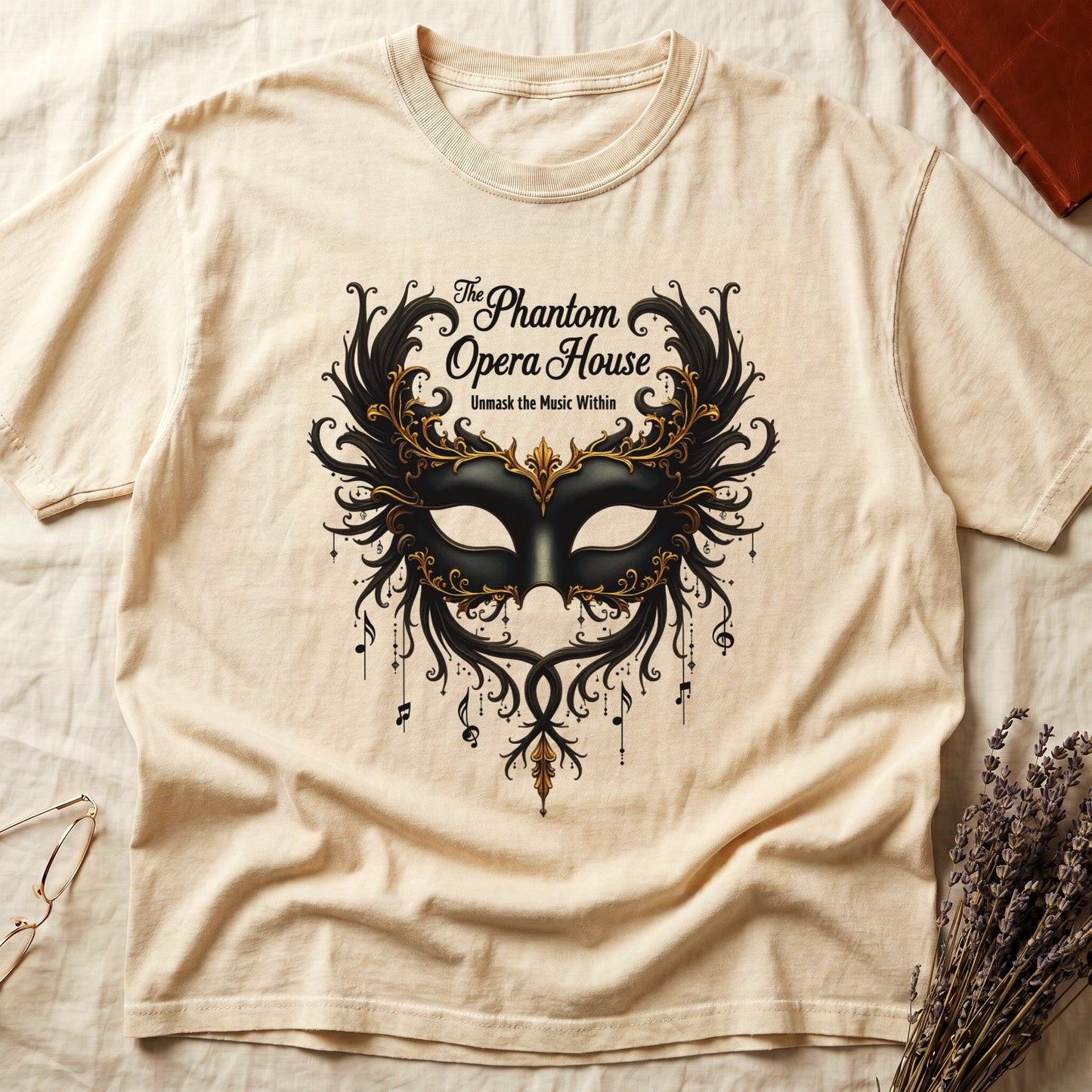Ivory tee with gold-and-black masquerade mask, scrollwork wings, "The Phantom Opera House," "Unmask the Music Within."