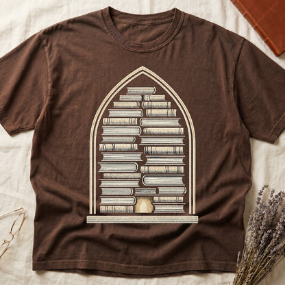 Espresso tee with gothic arch frame, columns of leather-bound books inside, sunburst medallion at base, cream engraved linework.