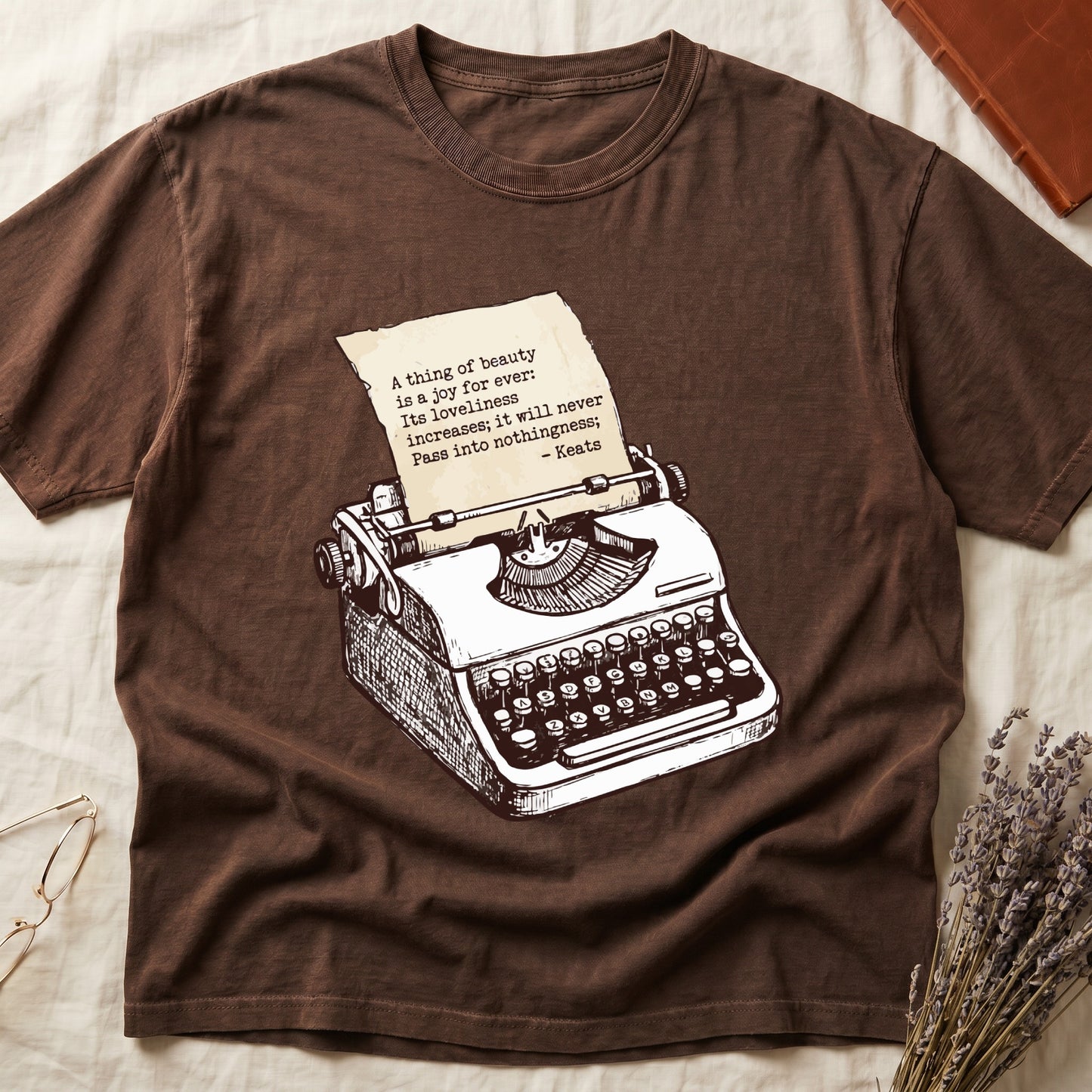 Espresso tee with vintage typewriter in cream linework, paper showing "A thing of beauty is a joy for ever" by Keats.