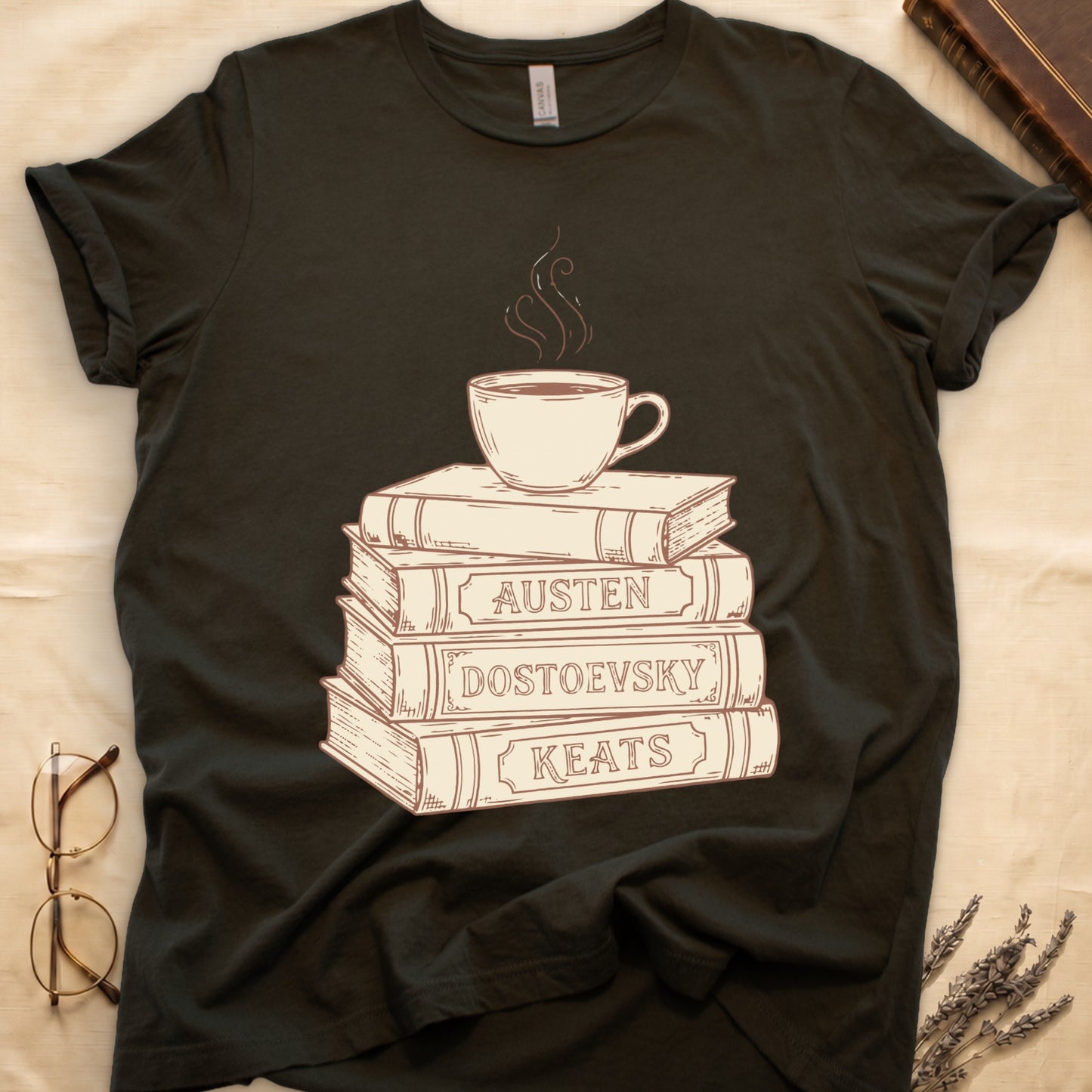 Military Green tee with stack of vintage books labeled "AUSTEN," "DOSTOEVSKY," "KEATS" topped with a steaming coffee cup.