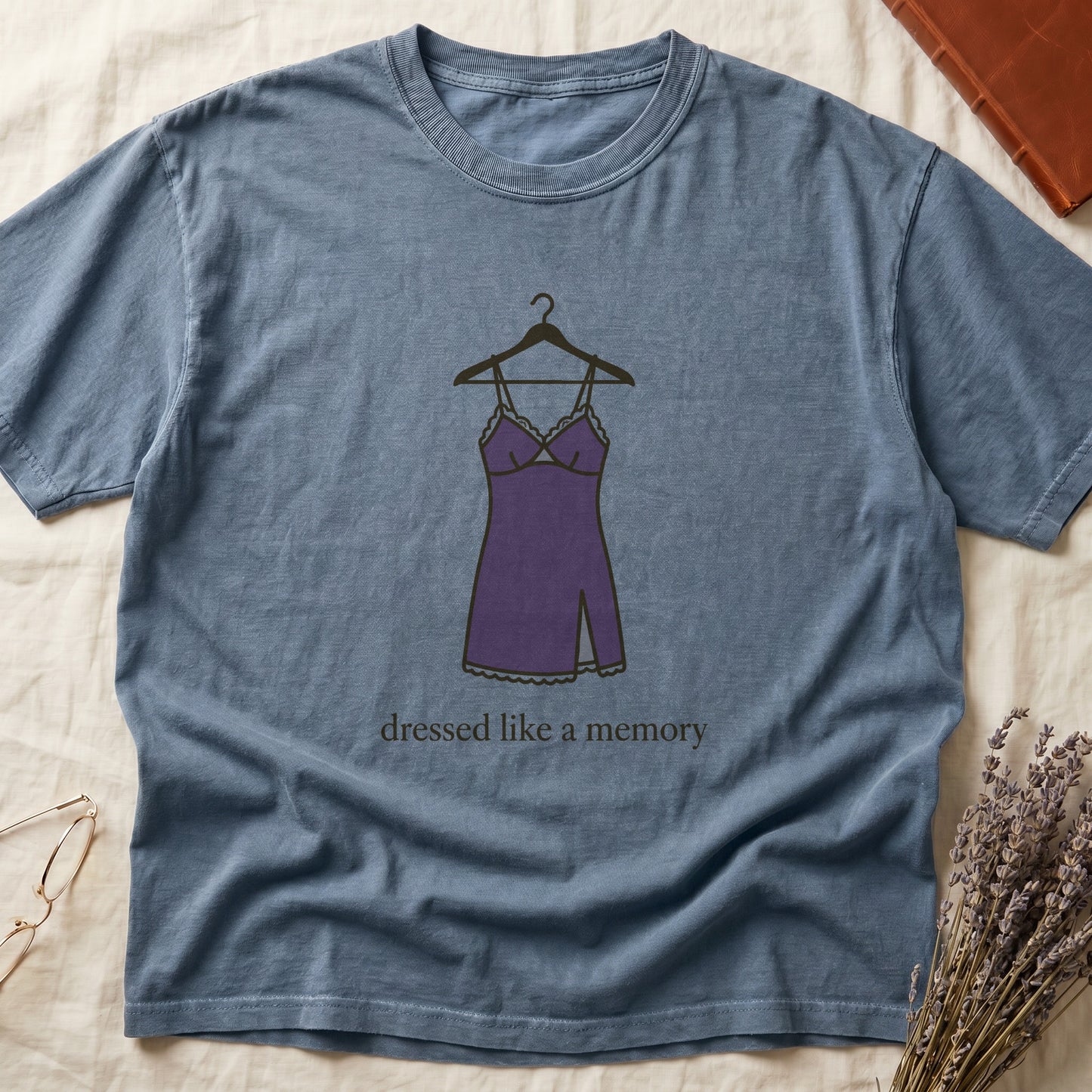 Blue Jean tee with dusty plum slip dress on cream hanger and "dressed like a memory" in lowercase cream serif below.