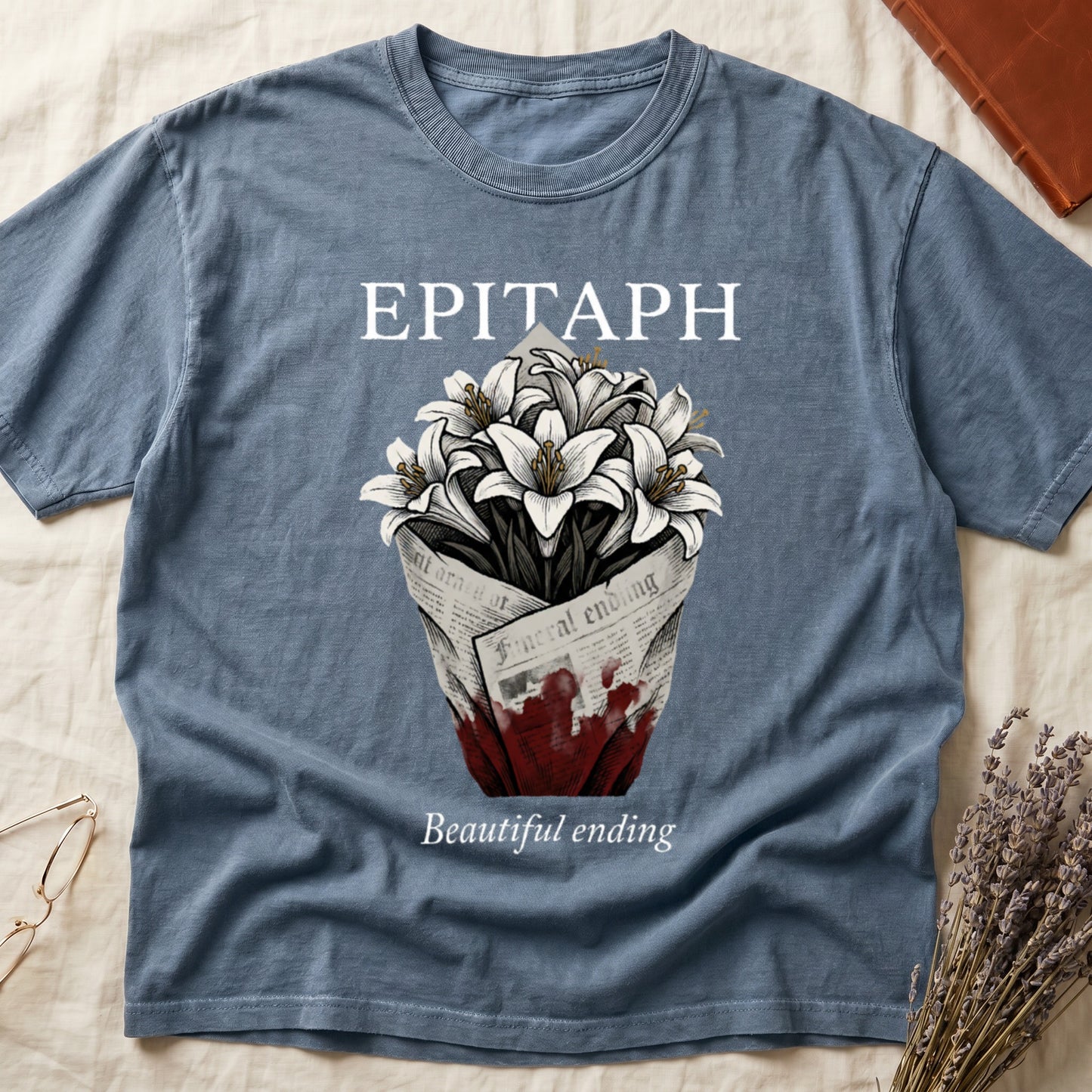 Blue Jean tee with "EPITAPH" over crosshatched white lilies in blood-stained newsprint wrap, "Beautiful ending" italic serif.