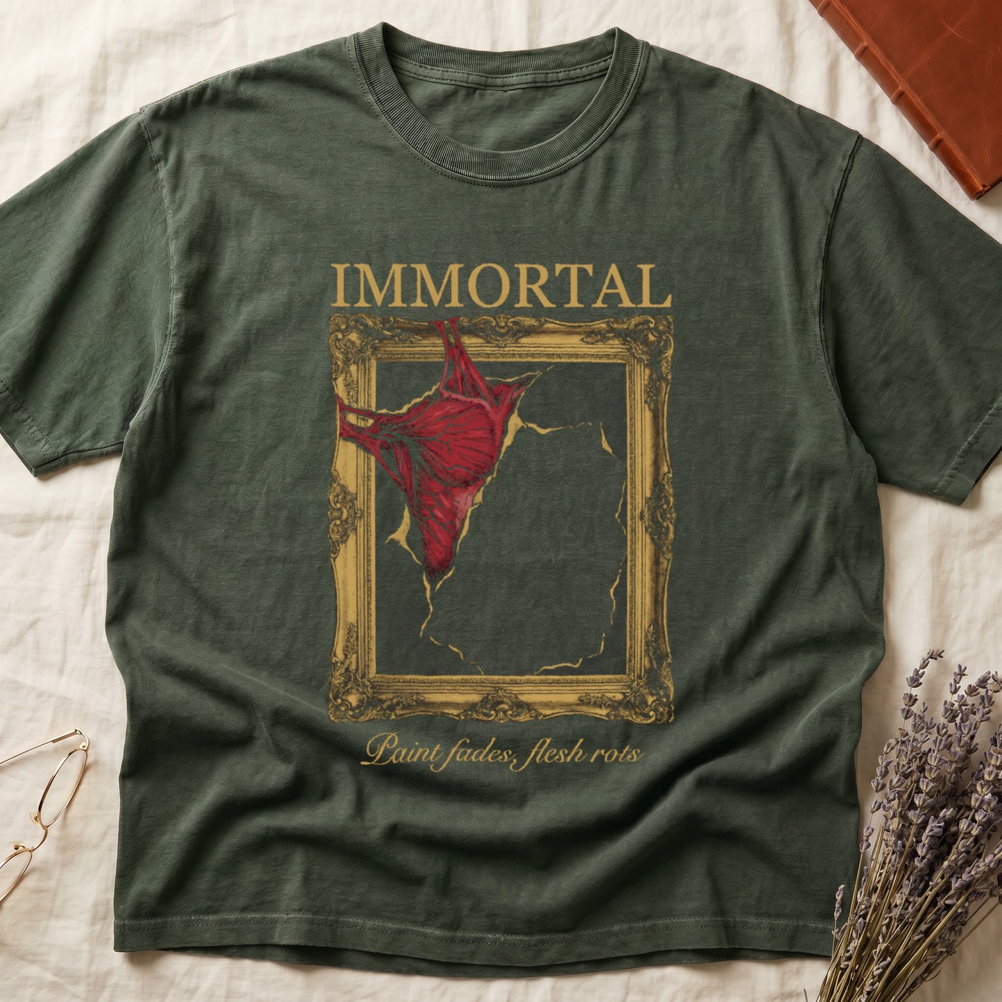 Green tee with gold frame and exposed muscle tearing canvas, "IMMORTAL" top, "Paint fades, flesh rots" italic below.