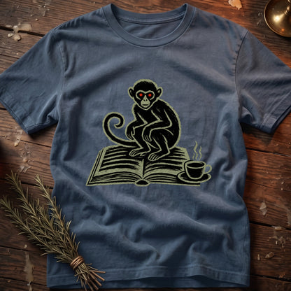 Blue t-shirt with a graphic of a monkey sitting on an open book with a cup of coffee.