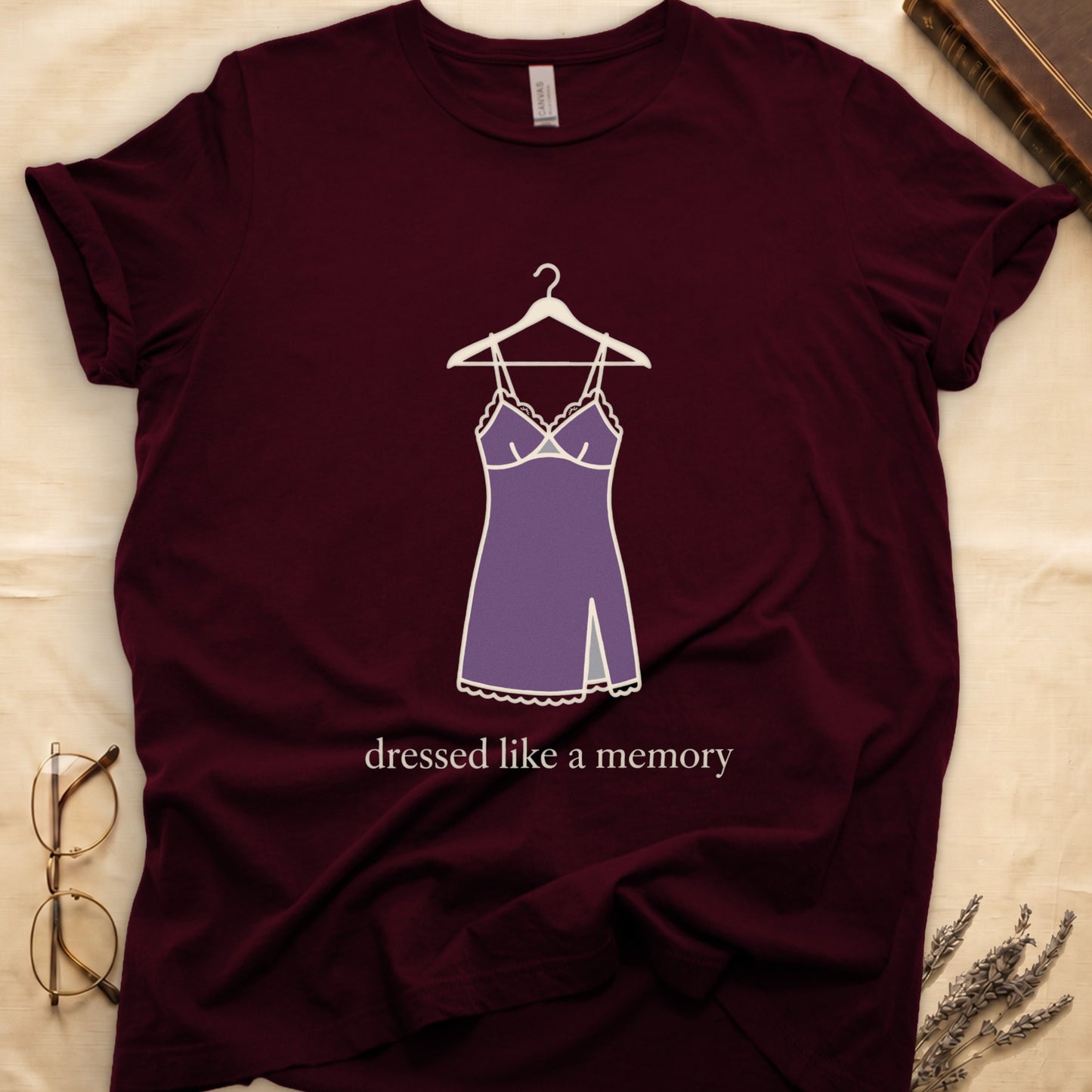 Maroon tee with dusty plum slip dress on cream hanger and "dressed like a memory" in lowercase cream serif below.