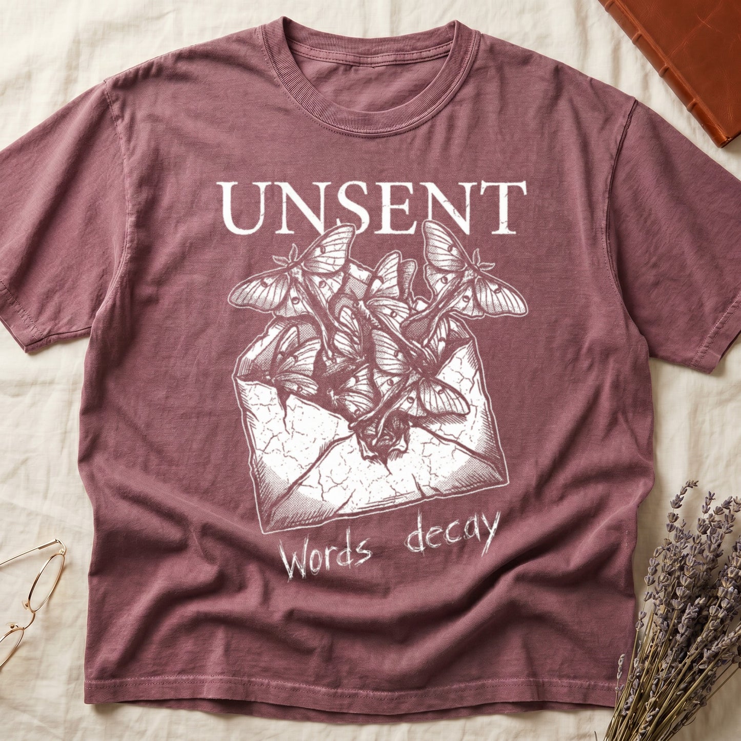 Dark Rose tee with 'UNSENT' in serif type, 'Words decay' brush text, luna moths from torn envelope in crosshatched ink