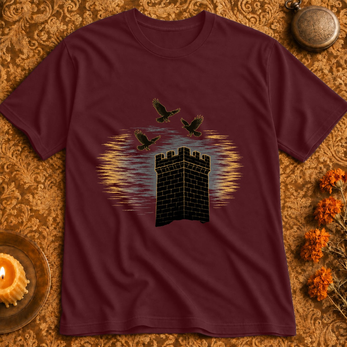 Maroon t-shirt with black brick tower and three flying crows against a sunset.