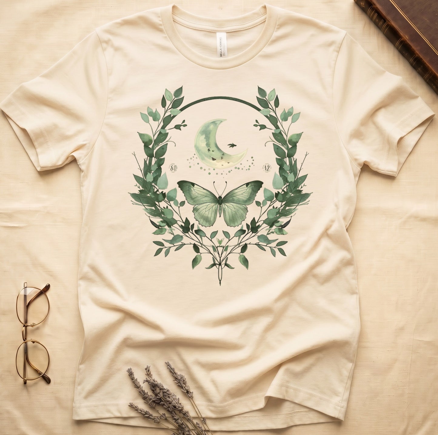 Cream t-shirt with moon, butterfly, and leafy wreath graphic and numbers 50 and 12.