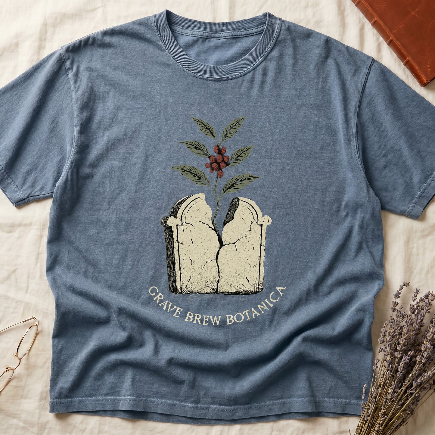 Blue t-shirt with "Grave Brew Botanica" text and cracked tombstone graphic.