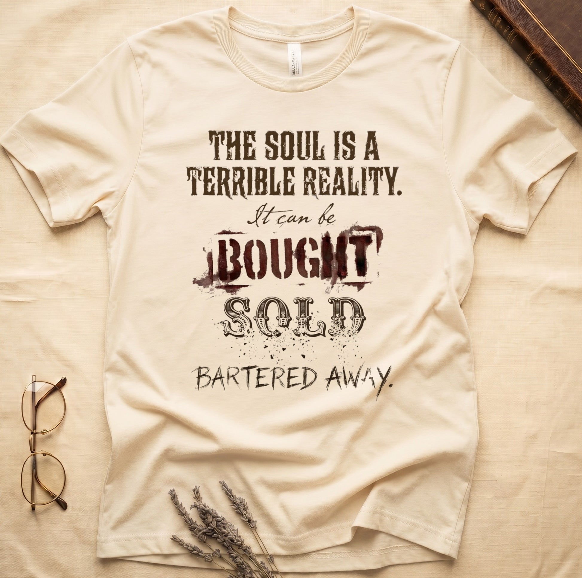 Black tee with distressed western type, "THE SOUL IS A TERRIBLE REALITY. It can be BOUGHT SOLD BARTERED AWAY."