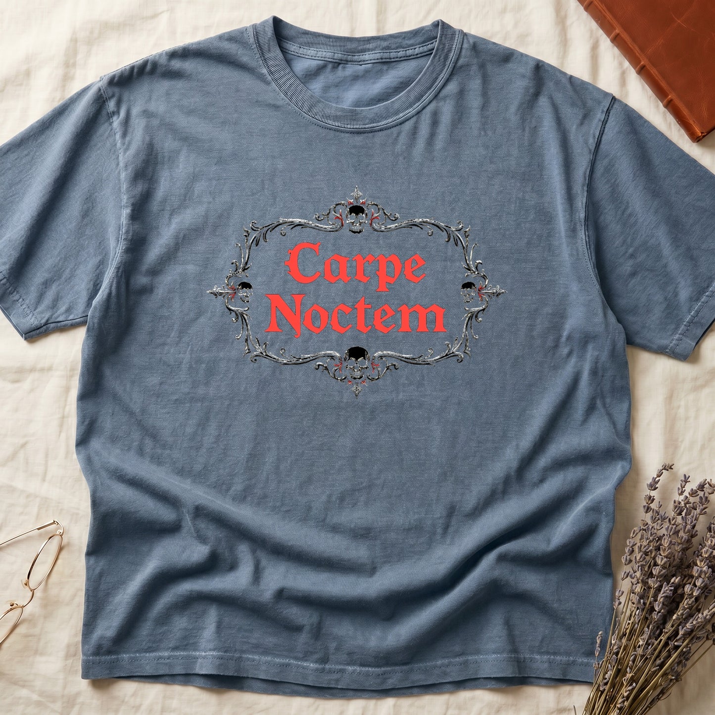 Blue Jean tee with silver filigree cartouche, crowned skull top and skull below, "Carpe Noctem" in deep-red blackletter inside.