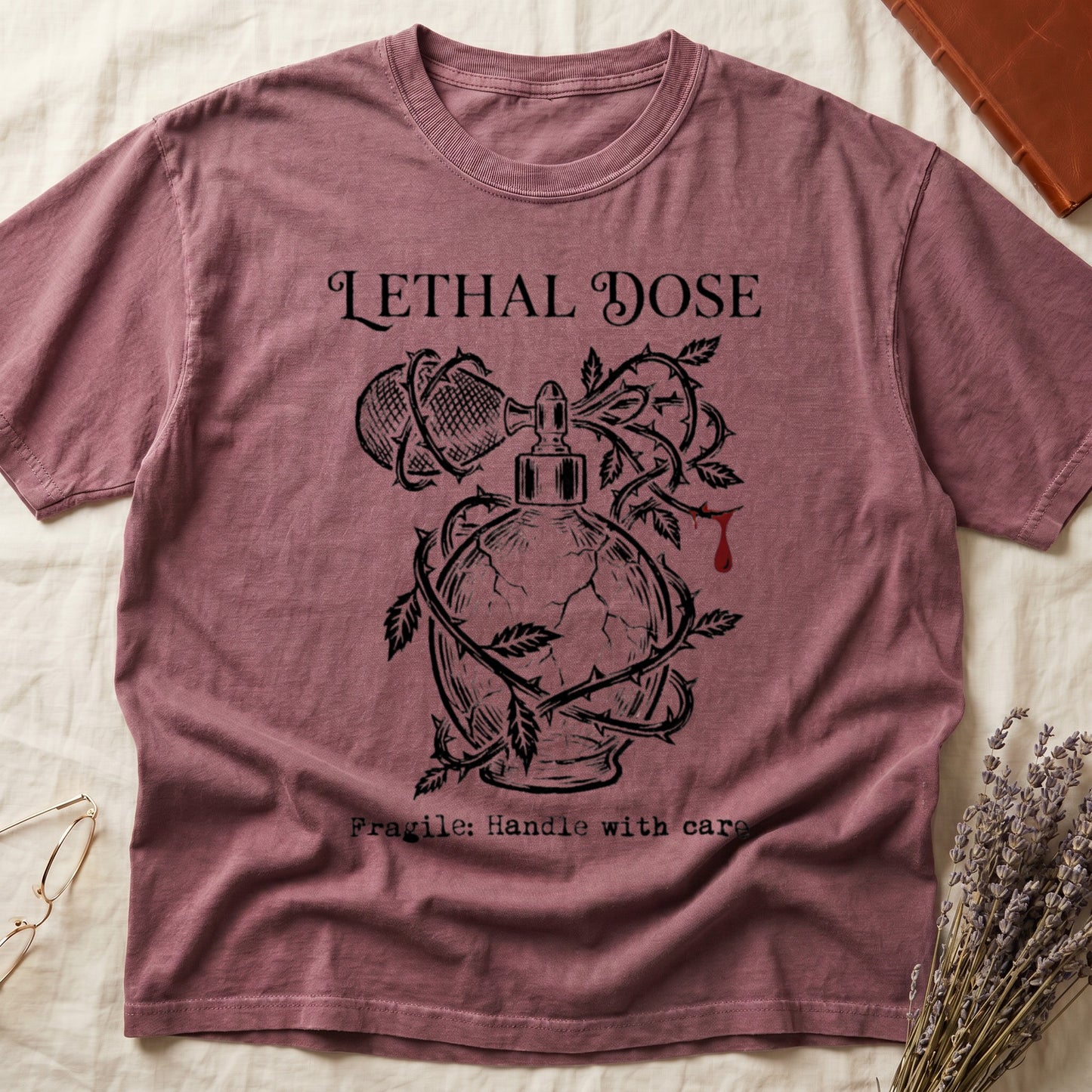 Dark Rose tee with cracked perfume bottle wrapped in thorns, blood drop, "LETHAL DOSE" top, "Fragile: Handle with care" below.
