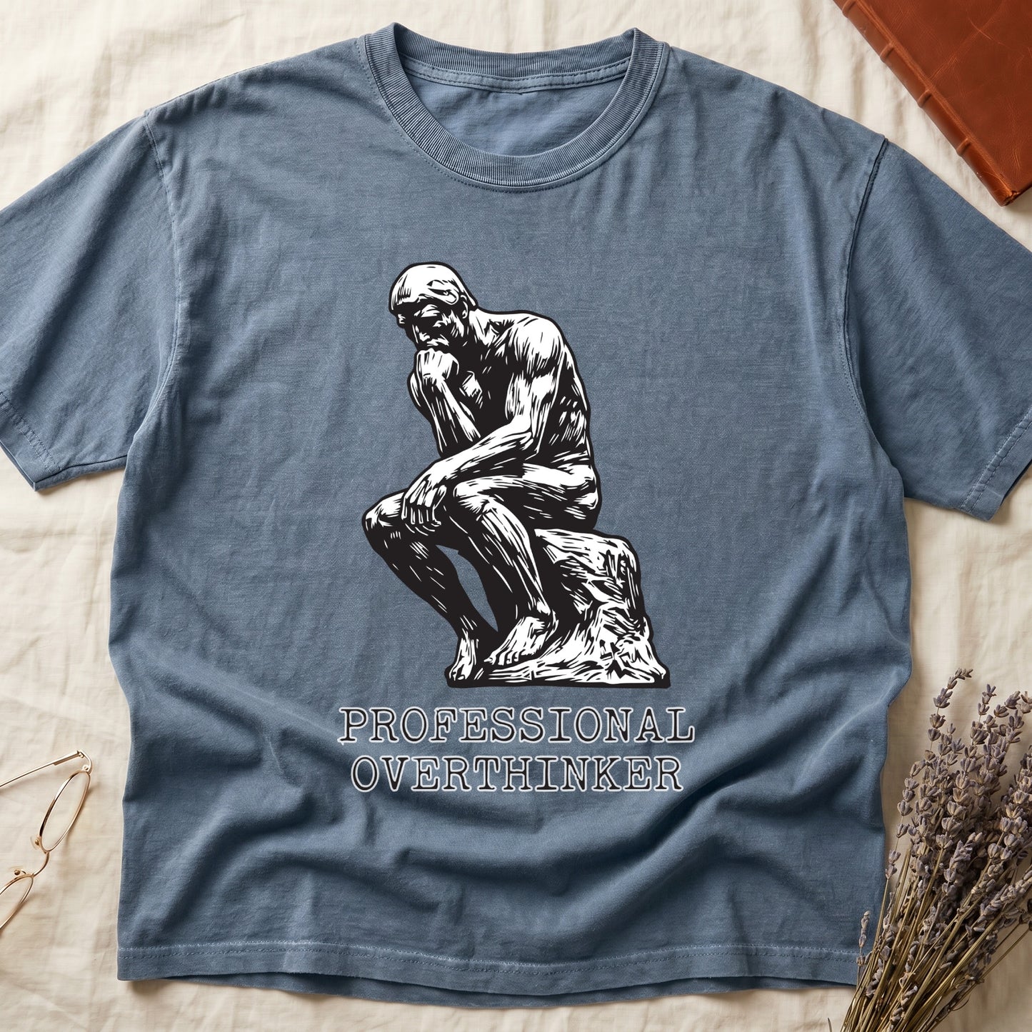 Blue Jean tee with monochrome rendering of Rodin's Thinker, "PROFESSIONAL OVERTHINKER" in serif capitals below.