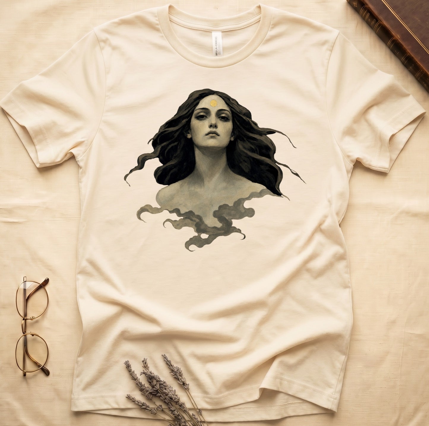 Cream t-shirt with vintage-style illustration of a woman with dark hair and a gold sun on her forehead.