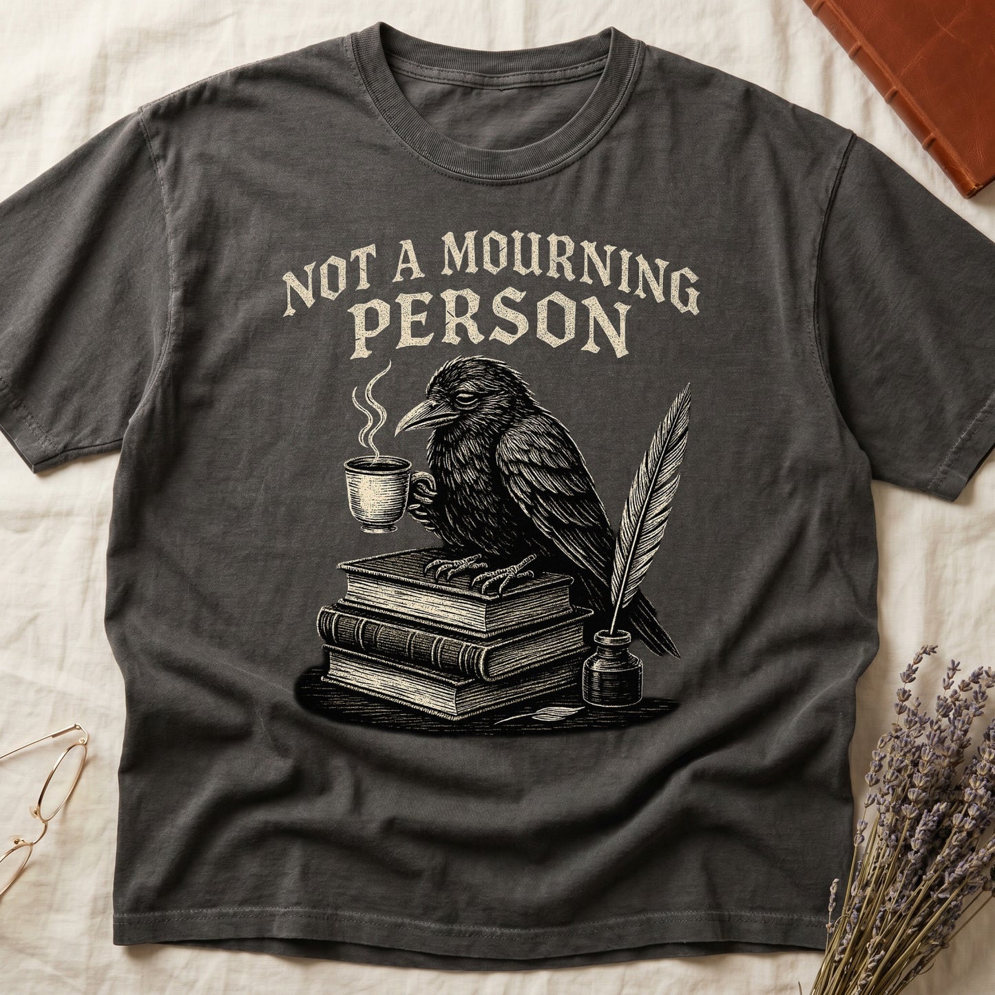 Green tee with raven holding coffee on stack of books, quill in inkwell, "NOT A MOURNING PERSON" distressed serif top.