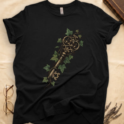 Black tee with ornate antique skeleton key in bronze, climbing English ivy in green on terracotta ground.