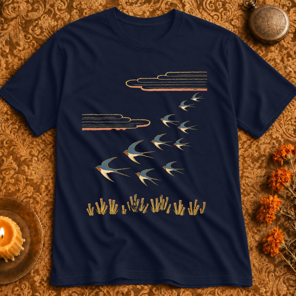 Navy t-shirt with a flock of swallows flying under stylized clouds and grass.